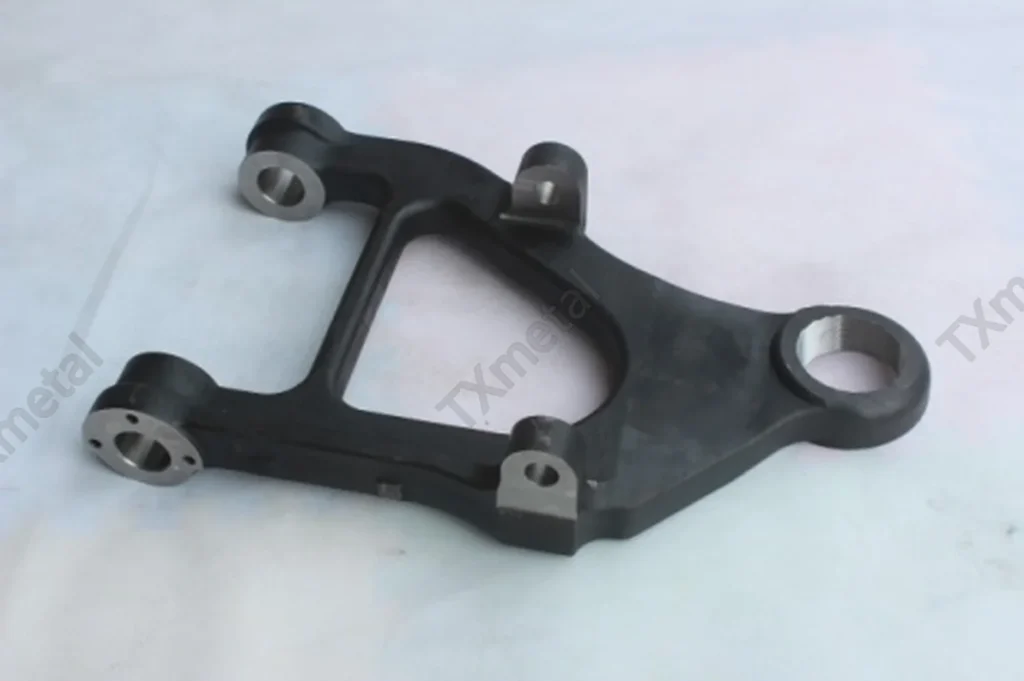 Ductile iron suspension bracket casting with machining for automotive chassis system.