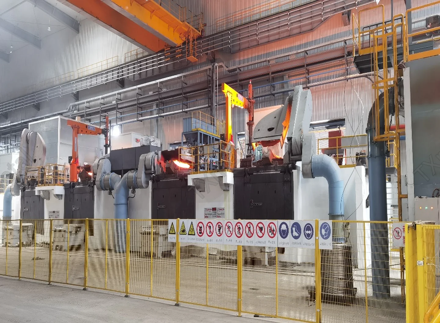 Multi-station tilting ladle automatic pouring line in TXmetal foundry with molten metal handling.